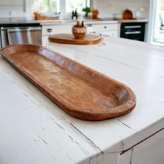 a large wooden tray sitting on top of a white kitchen counter next to an oven