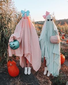 two people dressed up in costumes standing next to pumpkins