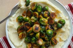 a white plate topped with mashed potatoes and brussel sprouts