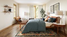 a bedroom with hardwood floors and white walls, including a bed covered in blue blankets