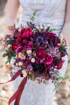 a bridal holding a bouquet of red and purple flowers