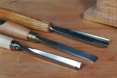 three different types of knives on a wooden table