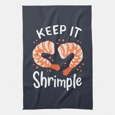 a towel that says keep it shrimpple on the front, and two croissants in the middle