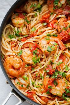 a bowl filled with pasta and shrimp on top of a table