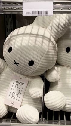 a white stuffed animal sitting on top of a shelf