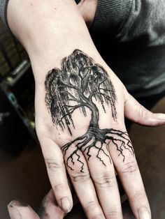 a person's hand with a tree tattoo on it