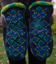 someone is wearing slippers with green and blue designs on them while standing in the grass