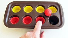 a person pointing at an egg tray with nine eggs in it and one hand on the side