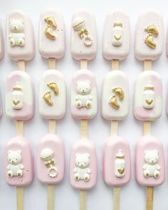 there are many pink and white marshmallows with gold teddy bears on them