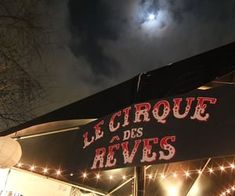 the sign for le cirque des reves is lit up at night time