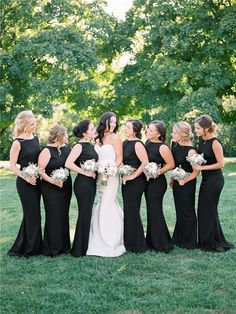 a group of women standing next to each other on top of a lush green field