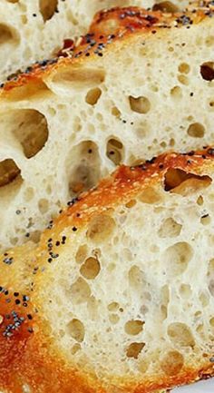 slices of bread with poppy seed sprinkles on white surface, closeup