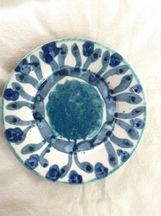 a blue and white plate sitting on top of a bed