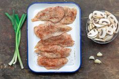 raw chicken and mushrooms on a plate with seasoning next to it, ready to be cooked