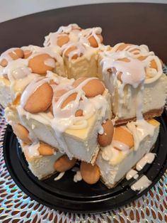 a black plate topped with slices of cake covered in white frosting