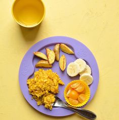 a purple plate topped with different types of food next to a cup and saucer