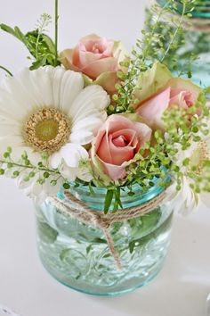 two mason jars filled with flowers on top of a table