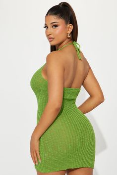 a woman in a green dress with her hands on her hips and one hand on her hip