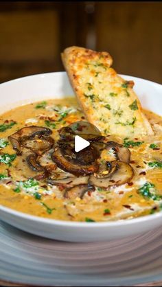 a white bowl filled with soup and some bread