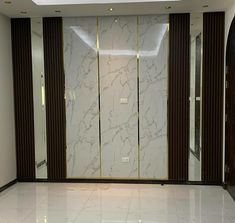 an empty room with marble floors and glass doors on the wall, in front of a doorway