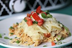 a white plate topped with lasagna covered in cheese and veggies