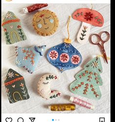 an image of christmas ornaments on the table with scissors and thread spools next to them