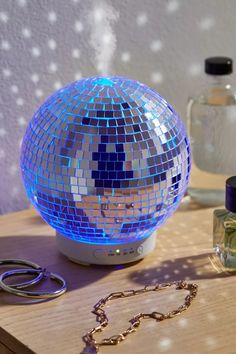 a disco ball sitting on top of a wooden table next to a pair of scissors