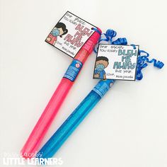 two blue and pink pens sitting next to each other on top of a white table