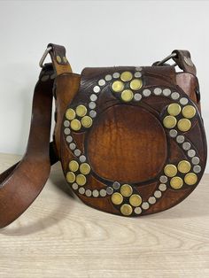 Really unique Vintage Hand Tooled hand Stitched Leather Shoulder Bag/Purse With Metal Rivets Deco Really Thick Leather boho, weight over 1lb13oz. The bag is 9" wide 8" height and 4'" deep. The strap is not adjustable. From the bottom of the bag to the far end of the strap is a little bit over 25”. There is one metal rivet missing, you can see it from the last photo, which is not effect the use of the bag. Please check all the photos for details as they are part of the description. Shipped with U Bohemian Leather Bags As Fashion Accessory, Leather Bohemian Pouch Bag, Bohemian Leather Pouch Bag, Leather Hand-stitched Shoulder Bag, Bohemian Leather Shoulder Bag With Leather Handles, Leather Pouch Shoulder Bag For Festivals, Bohemian Pouch Shoulder Bag With Hand-stitched Details, Bohemian Leather Bags With Leather Handles, Bohemian Leather Shoulder Bag For Daily Use