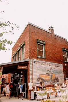 an old brick building with people standing outside