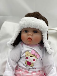 a baby doll wearing a white shirt with a brown hat on it's head