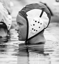 two people in the water wearing swimming caps