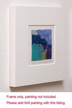 a white frame hanging on the wall with an image of a blue and purple painting in it