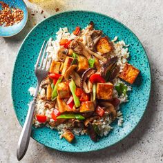 a blue plate topped with tofu and rice