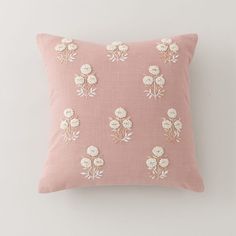 a pink pillow with white flowers on it