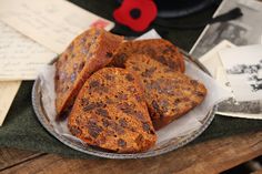 there are pieces of bread on the plate and some papers next to it with red poppies