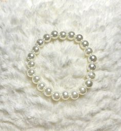 This handmade elastic bracelet is a coquette styled accessory.                                                                  It is the perfect pearl bracelet to combine with any other accessory. I make each bracelets by hand using elastic to draw the pearls on. The sizes of the bracelets come in different sizes. The size corresponds to the  length of the bracelet. Sizes are: extra small (5.5in/14cm), small (6in/15cm), medium (7in/18cm), large (8in/20cm), extra large (8.5in/22cm). Stretch Bracelet With Pearl Charm And Round Beads, Classic Stretch Bracelet With Pearl Beads, Classic Pearl Stretch Bracelet As Gift, Classic Pearl Stretch Bracelet Gift, Classic Pearl Stretch Bracelet For Gifts, Elegant Hypoallergenic Pearl Stretch Bracelet, Pearl White Pearl Bracelet With Round Beads, Classic White Pearl Stretch Bracelet, Pearl Stretch Bracelet With Round Beads