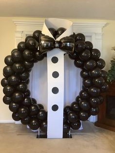 a black and white balloon wreath with a bow