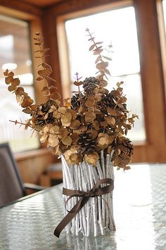 a vase filled with lots of flowers sitting on top of a table next to a window