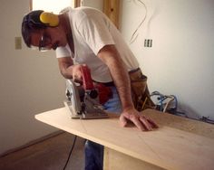 a man is working on a table with a power drill and a cordless saw