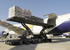 an airplane being loaded with luggage on the tarmac