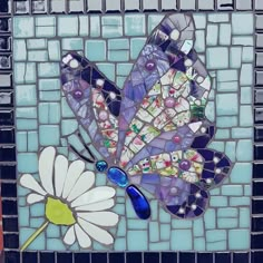 a mosaic tile wall with a flower and butterfly on it