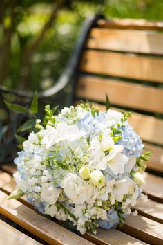 a bridal bouquet sitting on top of a wooden bench next to a park bench