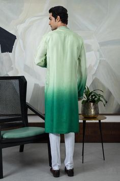 Green ombre silk kurta with geometric pattern silver rexin, thread hand embroidered mandarin collar and placket. Paired with malai cotton contrast ivory pant pyjama.
Components: 2
Pattern: Hand Embroidered
Type Of Work: Thread and Rexin Work
Neckline: Mandarin Collar
Sleeve Type: Full Sleeves
Fabric: Kurta: Silk, Pant: Malai Cotton
Color: Green
Other Details: 
Kurta Length: 42 inches
Side slits on kurta
Side pockets
Embroidered sleeve borders
Metallic buttons
Kurta Closure: Front concealed plack Silk Straight Kurta With Dabka Details, Silk Straight Kurta With Dabka, Transitional Silk Kurta With Dabka Detailing, Silk Sherwani With Dabka Work, Semi-stitched Silk Sherwani Straight Kurta, Silk Sherwani With Cutdana In Straight Kurta Style, Designer Silk Sherwani Straight Kurta, Silk Sherwani With Dabka Straight Kurta, Silk Designer Kurta For Eid