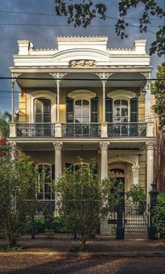 an old house with many windows and balconies on the second floor is painted yellow