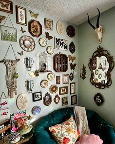 a living room filled with lots of different types of clocks on the wall next to a blue chair