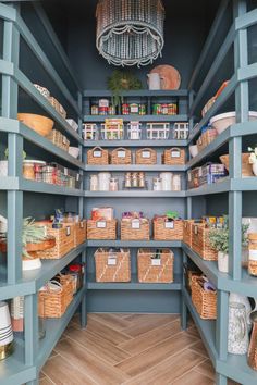 an organized pantry with lots of shelves and baskets