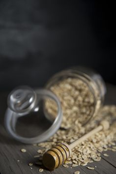 a glass jar filled with oatmeal next to a wooden spoon