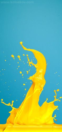 a yellow liquid splashing into the blue sky