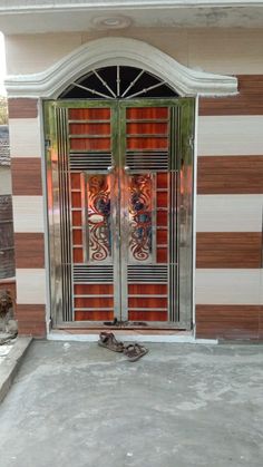 an entrance to a building with two glass doors and decorative designs on the front door